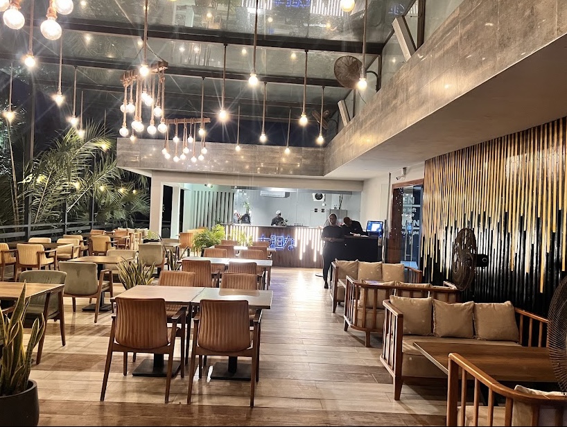 Main dining room with hanging lights and a wood slat wall