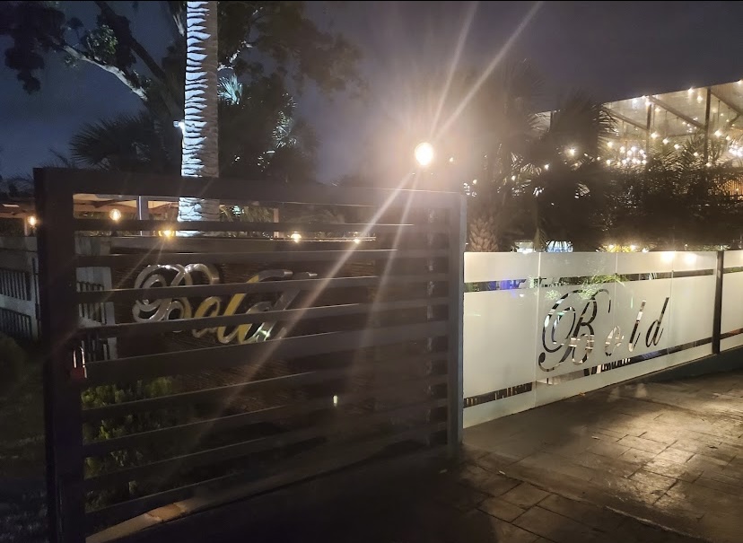 Bold entrance gate and sign at night
